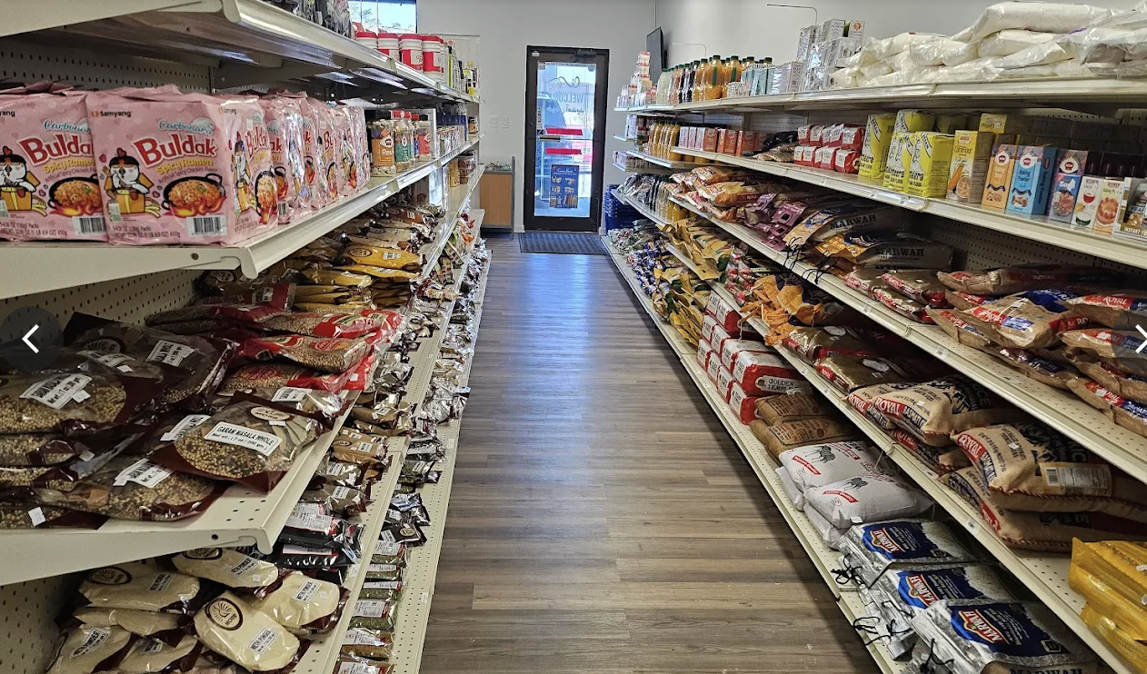 Grocery aisle stocked with rice, lentils, spices and snacks